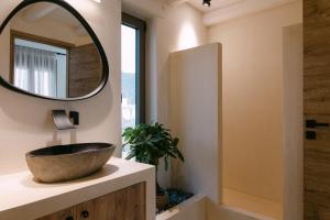 a bathroom with a bowl sink and a mirror at Villa Aldea - Luxury Boho Style in Melidhónion