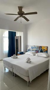 a bedroom with two beds and a ceiling fan at Maison Residencial casa de ferias in Santa Cruz