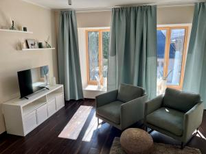 a living room with two chairs and a television at Troll's Brauhaushotel in Medebach