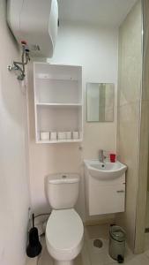 a white bathroom with a toilet and a sink at Maison Residencial casa de ferias in Santa Cruz