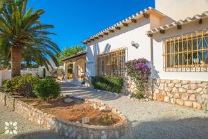 モライラにあるVilla Sol y Sombra by Abahana Villasの椰子の木と石壁の家