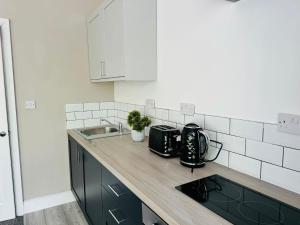 eine Küche mit einer Spüle und einer Arbeitsplatte in der Unterkunft Manzil by HeyHouseLife in Middlesbrough
