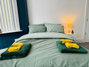 ein Bett mit zwei Handtüchern und Bananen drauf in der Unterkunft Manzil by HeyHouseLife in Middlesbrough