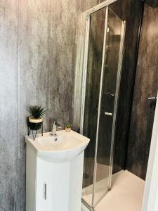ein Bad mit einem Waschbecken und einer Dusche in der Unterkunft Manzil by HeyHouseLife in Middlesbrough