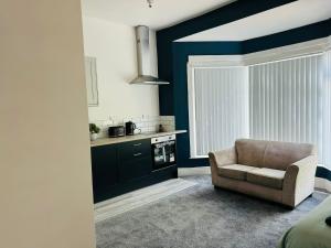 ein Wohnzimmer mit einem Stuhl und eine Küche in der Unterkunft Manzil by HeyHouseLife in Middlesbrough