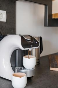 Eine Kaffeemaschine gießt Kaffee in eine Tasse in der Unterkunft Casa Cava in Pučišća