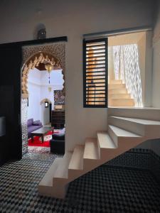 un salon avec un escalier menant à une chambre dans l'établissement RiadLalZahra, à Rabat