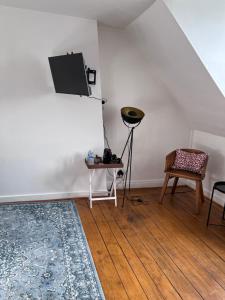 ein Wohnzimmer mit einem TV, einem Tisch und einem Stuhl in der Unterkunft Maison POL Amboise in Amboise