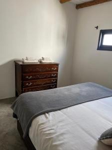 a bedroom with a bed with a dresser and a window at El Garzal in Mercedes