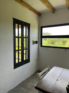 an empty room with a wooden table and a window at El Garzal in Mercedes