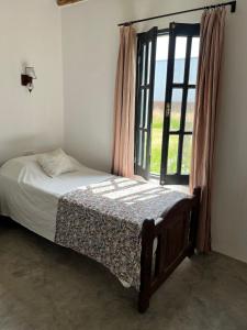 a bedroom with a bed and a large window at El Garzal in Mercedes