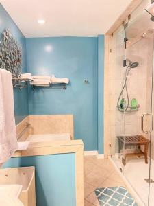 La salle de bains bleue est pourvue d'une douche et d'une baignoire. dans l'établissement Larry's Lancaster Landing: with fully-fenced yard, à Lancaster