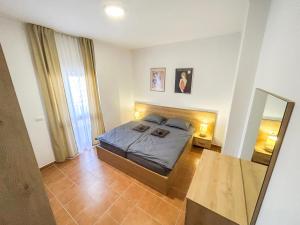 een slaapkamer met een bed en een spiegel bij Vacation 988 in Durrës