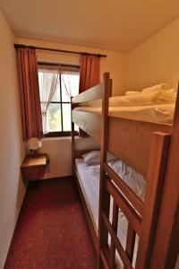 Dos literas en una habitación con ventana. en Apartment 12 - Ferienresidenz Roseneck, 2 Schlafzimmer, mit Schwimmbad in Todtnauberg bei Feldberg, en Todtnauberg