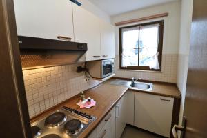 Una pequeña cocina con fregadero y estufa. en Apartment 12 - Ferienresidenz Roseneck, 2 Schlafzimmer, mit Schwimmbad in Todtnauberg bei Feldberg, en Todtnauberg 19 fotos más
