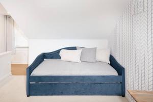 - un lit bleu avec deux oreillers dans l'établissement Larry's Lancaster Landing: with fully-fenced yard, à Lancaster