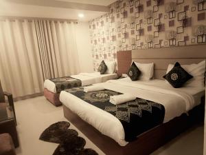 Hotel Ronit Royal - New Delhi Airport في نيودلهي: غرفة فندق بسريرين و افيسور