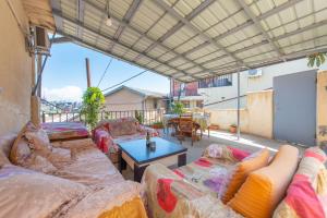 a living room with couches and a table on a balcony at Apartment Panorama in Tbilisi City