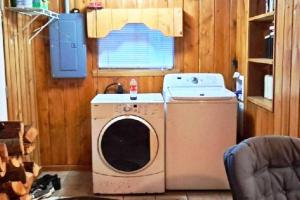een wasmachine en droger in een kamer met een raam bij ATV Getaway in Gladwin