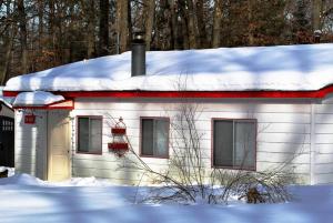 een klein wit huis met sneeuw op het dak bij ATV Getaway in Gladwin