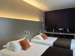 a hotel room with two beds with orange pillows at HOTEL & SPA Le Renard Centre in Châlons-en-Champagne