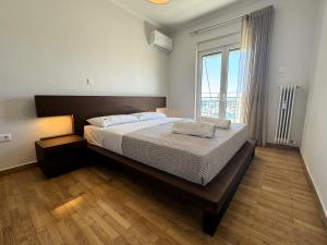um quarto com uma cama grande e uma janela grande em Piraeus center sea view apartment em Piraeus