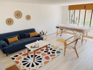 un salon avec un canapé bleu et une table dans l'établissement L'Atelier d'ici, à Thomery