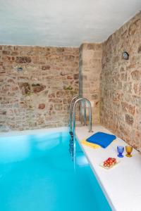 ein Schwimmbecken in einem Raum mit einer Steinwand in der Unterkunft Casa Cava in Pučišća