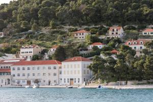 eine Gruppe von Gebäuden auf einem Hügel neben dem Wasser in der Unterkunft Casa Cava in Pučišća