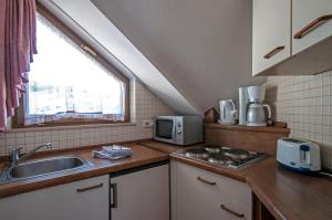 a small kitchen with a sink and a microwave at Apartment 15 - Ferienresidenz Roseneck, Galeriewohnung, mit Schwimmbad in Todtnauberg bei Feldberg in Todtnauberg
