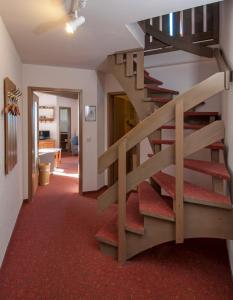 Apartment 15 - Ferienresidenz Roseneck, Galeriewohnung, mit Schwimmbad in Todtnauberg bei Feldberg في تودتنوبرغ: درج حلزوني في غرفة المعيشة مع سجادة حمراء