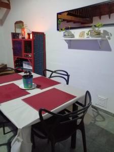 een eetkamer met 2 tafels met rode matten bij Depto en Villa Pehuenia in Villa Pehuenia