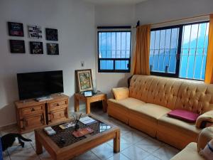ein Wohnzimmer mit einem Sofa und einem TV in der Unterkunft Rústica Azul in Tlaxcala de Xicohténcatl