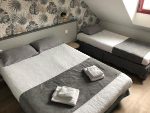 Rúm í herbergi á Logis Hôtel Lucotel