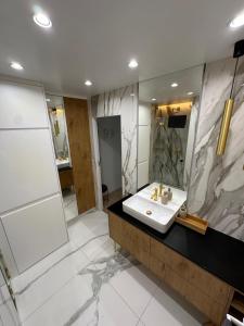 a bathroom with a sink and a mirror at Elegant Apartment Minutes from Paris in Issy-les-Moulineaux