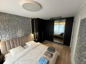 een slaapkamer met een bed en een grote spiegel bij Elegant Apartment Minutes from Paris in Issy-les-Moulineaux