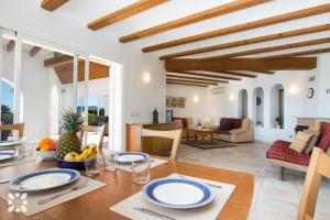 a dining room and living room with a table and chairs at Villa Soleada by Abahana Villas in Calpe