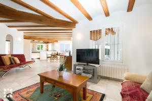 a living room with a tv and a table at Villa Soleada by Abahana Villas in Calpe