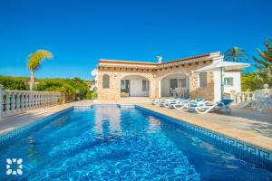 Villa con piscina frente a una casa en Villa Soleada by Abahana Villas, en Calpe