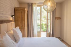 - une chambre avec un lit blanc et une fenêtre dans l'établissement Château du Parc - Gîtes & spas à Pézenas, à Pézenas