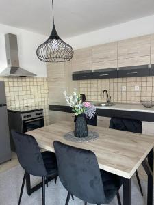 a kitchen with a wooden table with chairs and a vase with flowers at Taya in Mostar