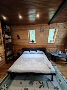 ein Schlafzimmer mit einem großen Bett in einem Holzzimmer in der Unterkunft Pola vendégház in Miskolc