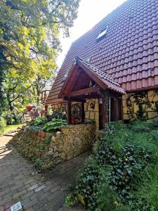 a house with a stone wall and a roof at Pola vendégház in Miskolc +7 photos