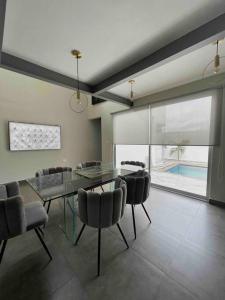 a dining room with a glass table and chairs at Casa de lujo Altozano Residencial con Piscina by AIRA 