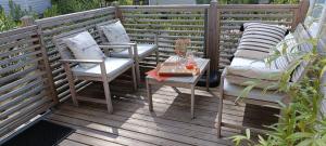 eine Terrasse mit Stühlen und einem Tisch auf einer Terrasse in der Unterkunft BUNGALOW - Cap Ferret in Lège-Cap-Ferret