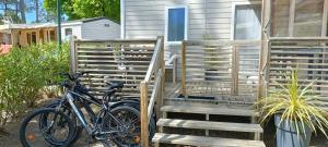 ein Fahrrad, das neben einem Haus mit Treppe geparkt ist in der Unterkunft BUNGALOW - Cap Ferret in Lège-Cap-Ferret
