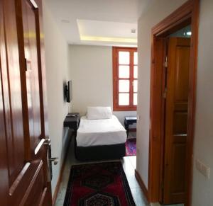 a small bedroom with a bed and a door at WOO Town Suites in Antalya