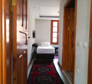 Habitación pequeña con cama y alfombra roja. en WOO Town Suites en Antalya