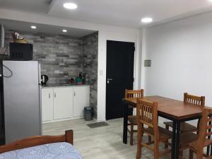 a kitchen with a dining room table and a refrigerator at Del Sur Aparts in El Calafate