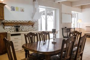 a dining room with a wooden table and chairs at Telšiai Inn in Telšiai